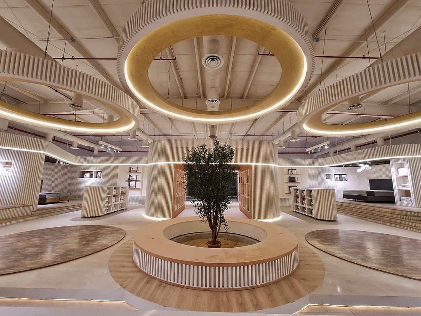 Lyvva showroom in Buraida: a curved timber-slat interior under a ring of light