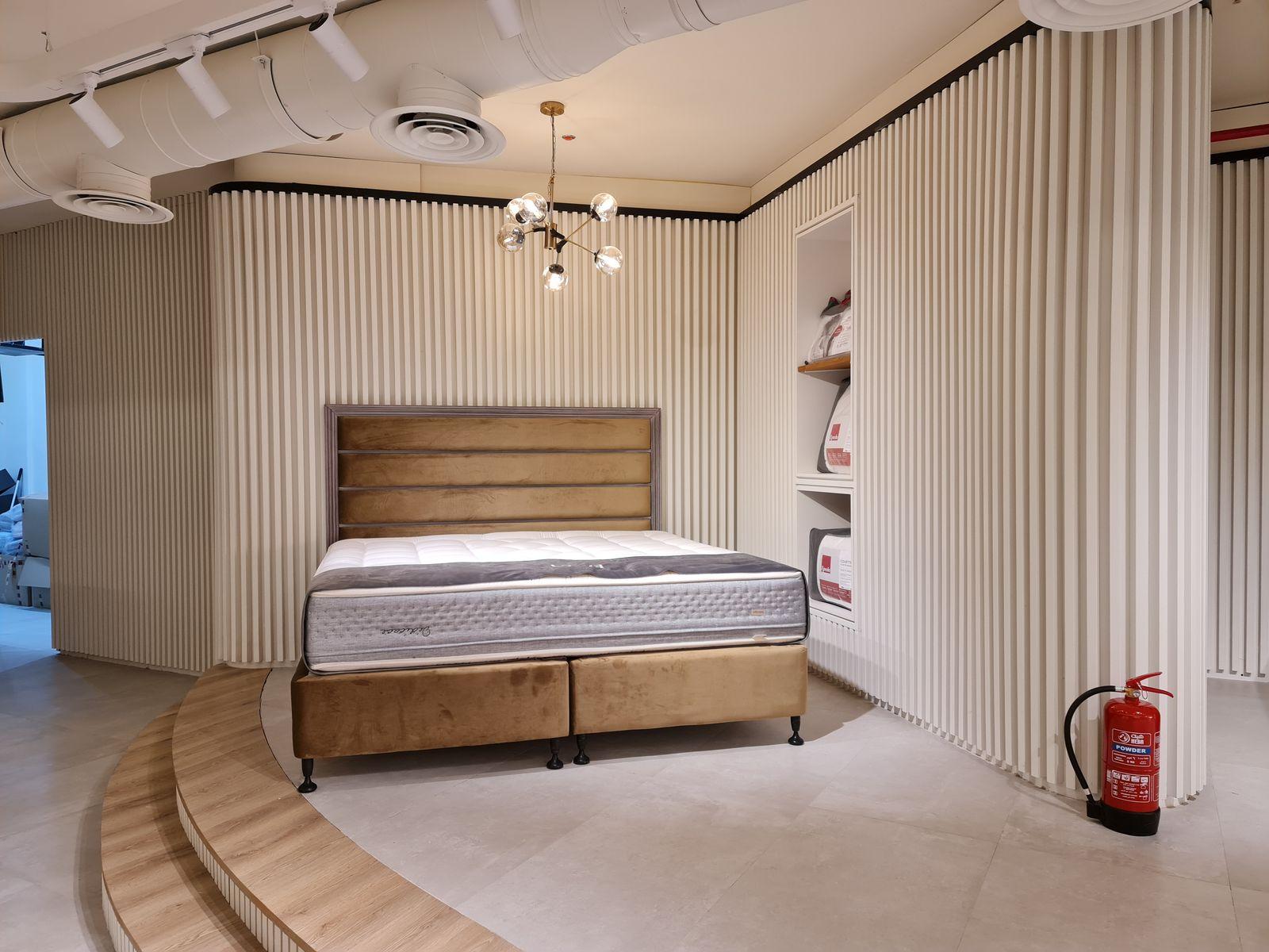 Lyvva showroom, Riyadh: a bed on the curved stepped platform beside the slatted walls
