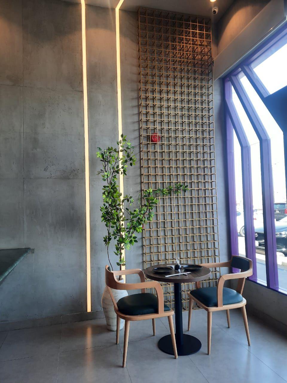 Masami Sushi, Riyadh: a window table beside a planted timber lattice screen and vertical light lines